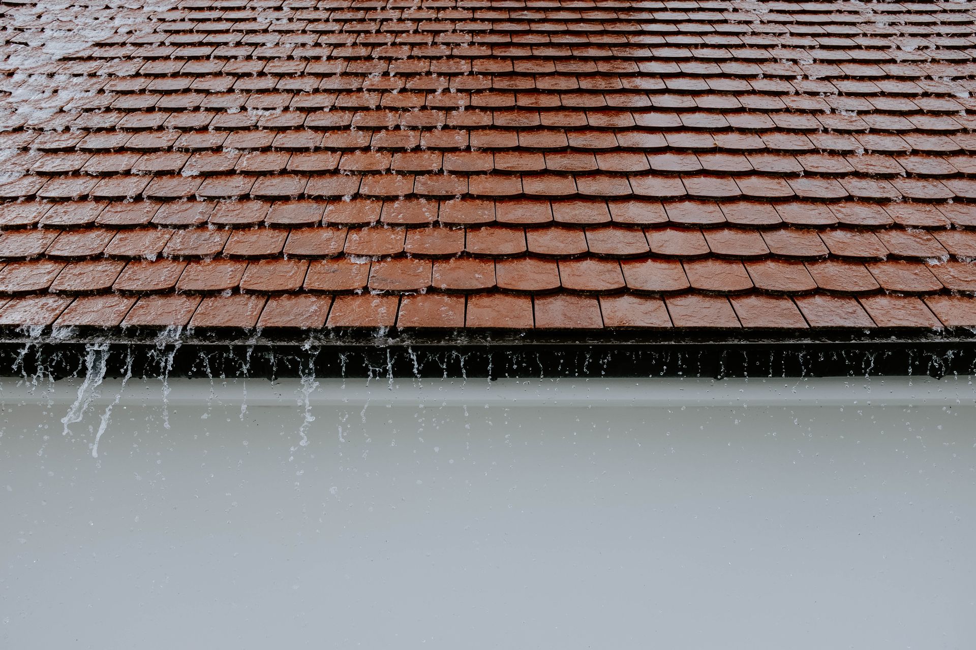 Rainwater running down roof tiles during a storm