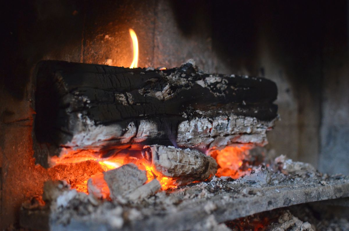 Before: smouldering logs and ash in a fireplace